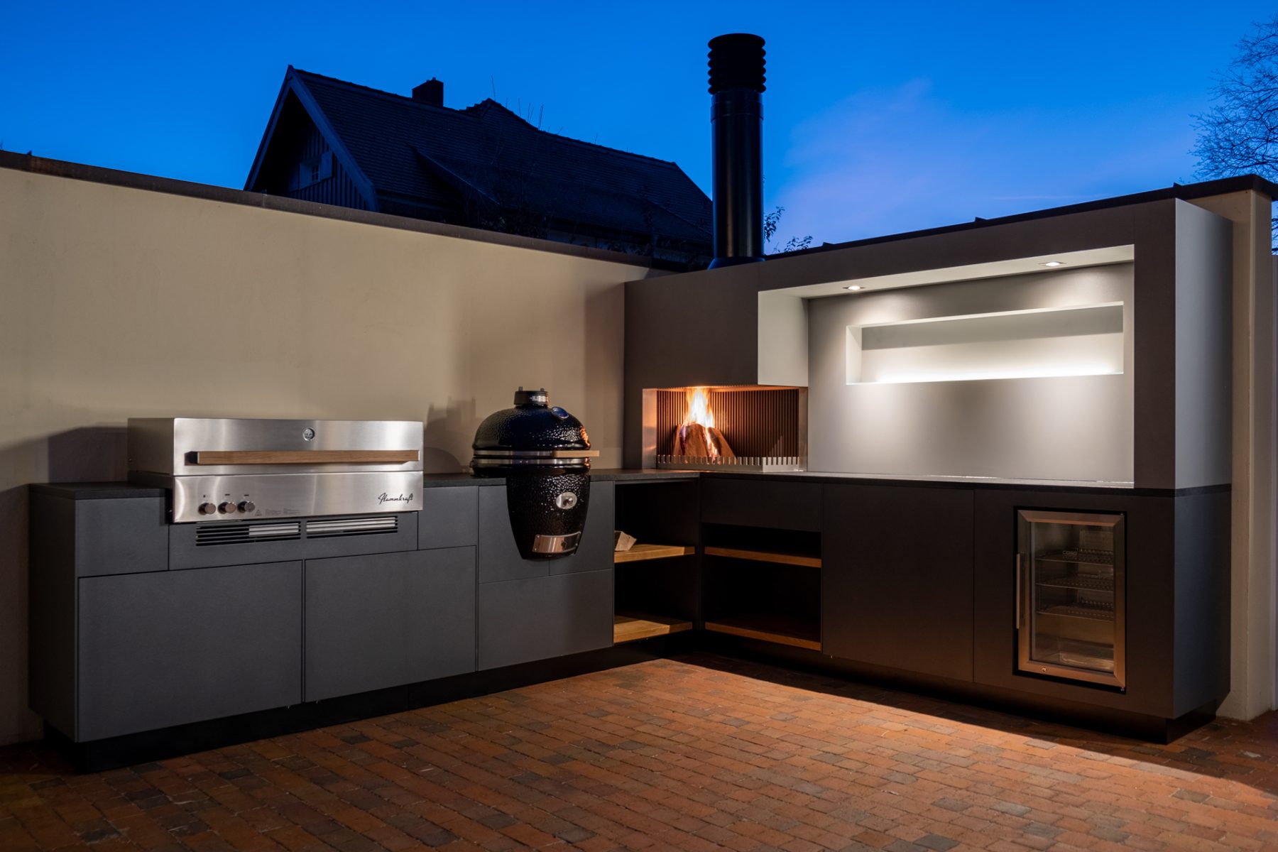 Freiluftküche mit Kamado Grill im Garten für eine atemberaubende Atmosphäre an kühlen Abenden.